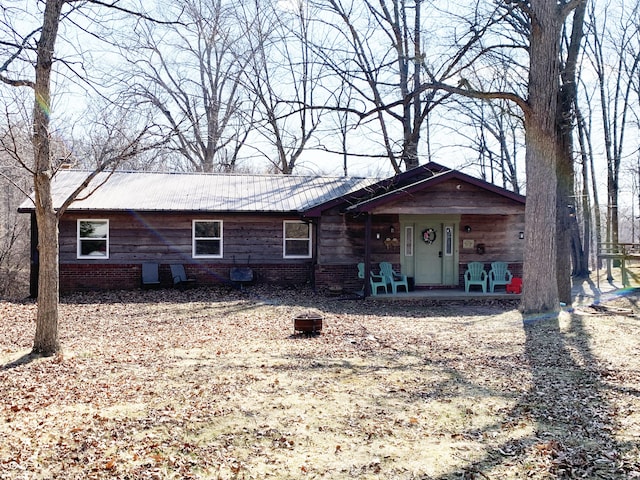 ranch-style home featuring covered porch and metal roof