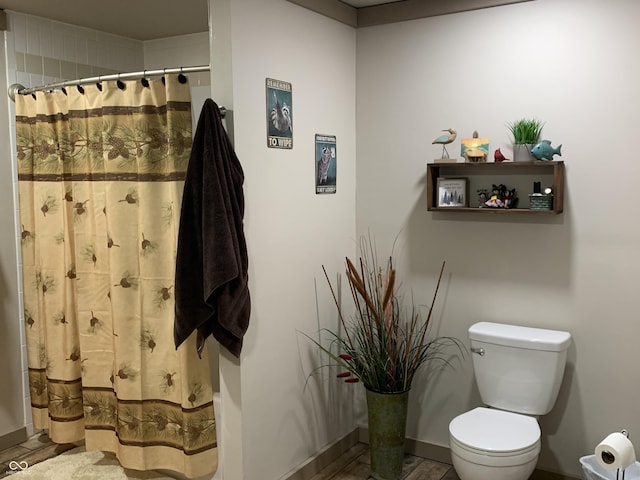 full bathroom featuring a shower with shower curtain, baseboards, and toilet