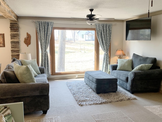 carpeted living area featuring a textured ceiling and ceiling fan