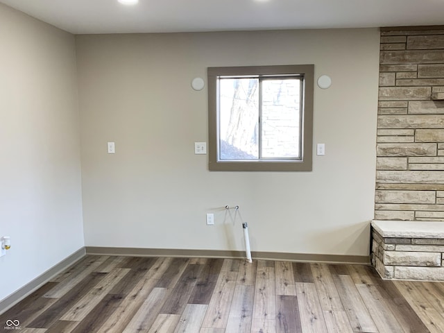 laundry area with laundry area, baseboards, and wood finished floors