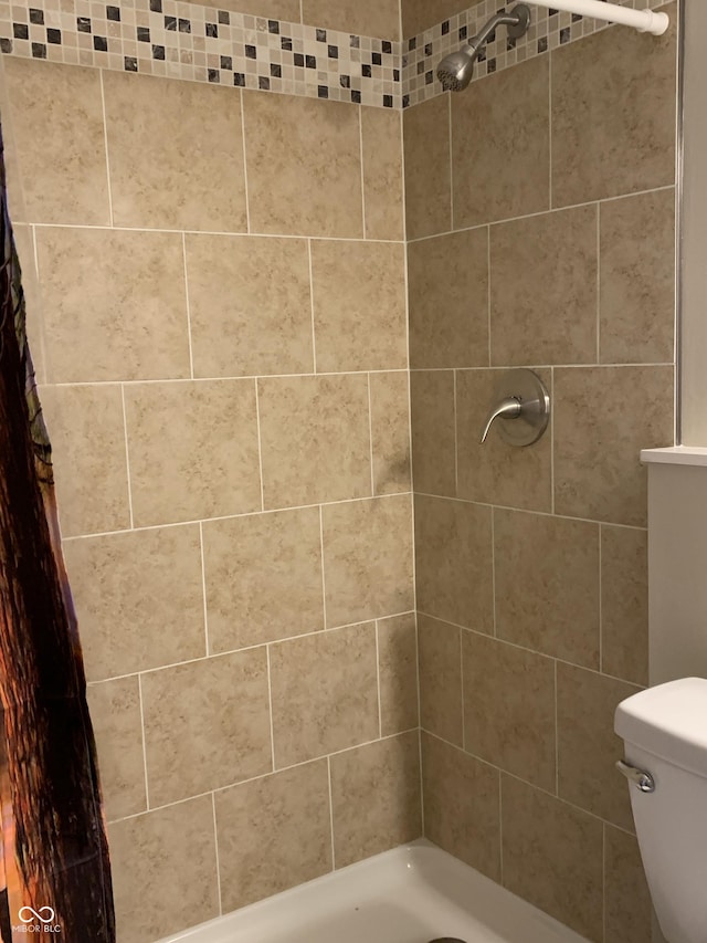 full bath featuring toilet and a tile shower