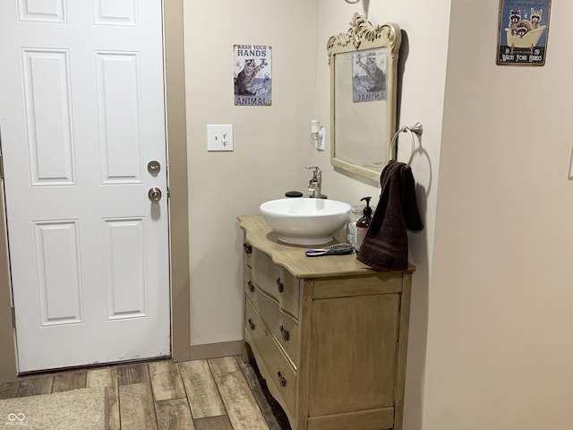 bathroom with baseboards, wood finished floors, and vanity