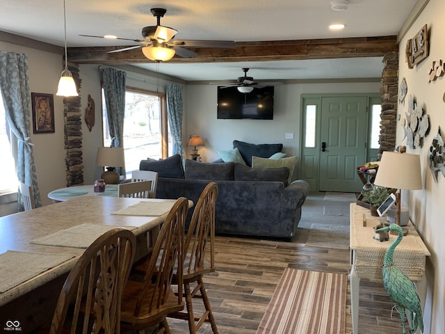 dining space with beamed ceiling, dark wood-style flooring, and ceiling fan