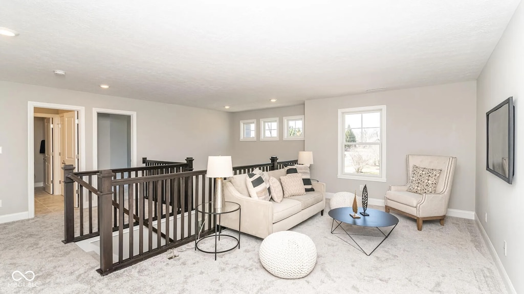 carpeted living area featuring recessed lighting and baseboards