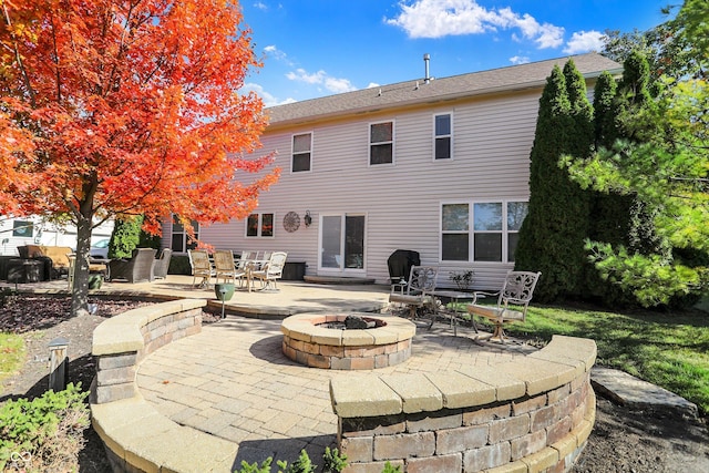 back of property featuring a patio area and a fire pit