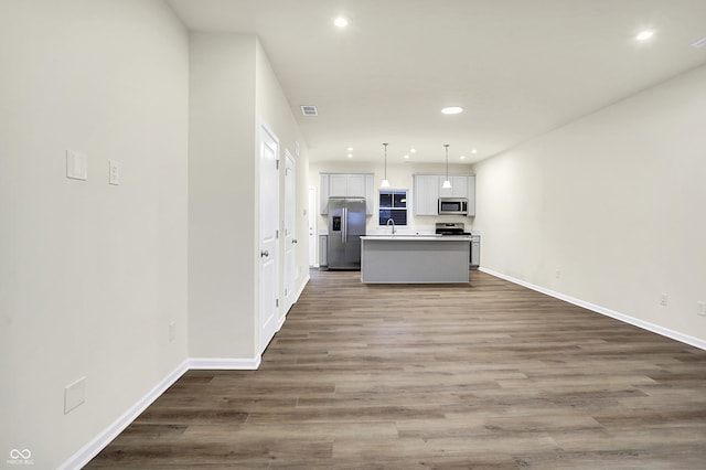 kitchen featuring visible vents, a center island with sink, recessed lighting, appliances with stainless steel finishes, and dark wood-style floors