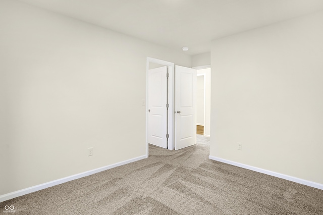 unfurnished bedroom featuring carpet flooring and baseboards