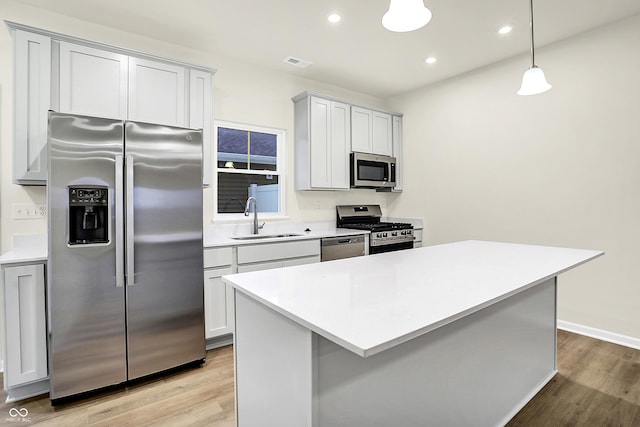 kitchen with light wood-type flooring, visible vents, appliances with stainless steel finishes, and a sink