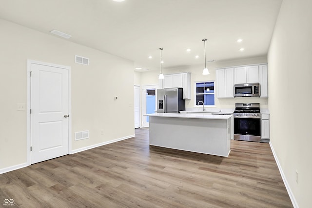 kitchen featuring a sink, stainless steel appliances, light wood-type flooring, and a kitchen island