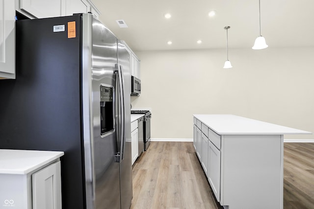 kitchen featuring light wood finished floors, a kitchen island, light countertops, recessed lighting, and appliances with stainless steel finishes