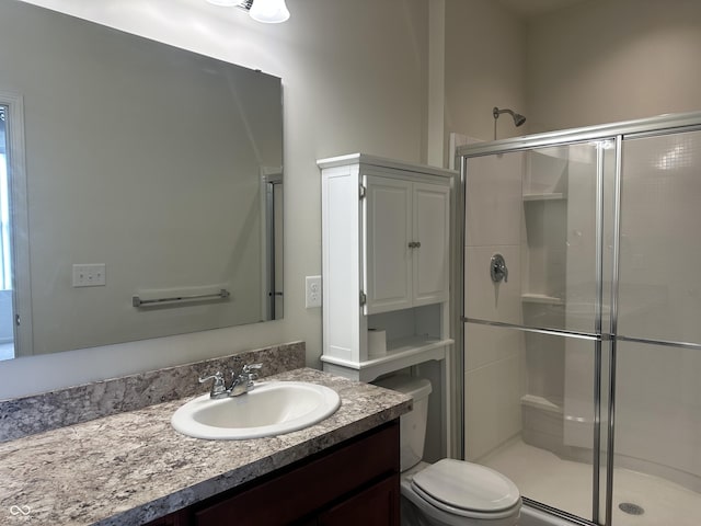 bathroom with vanity, toilet, and a shower stall