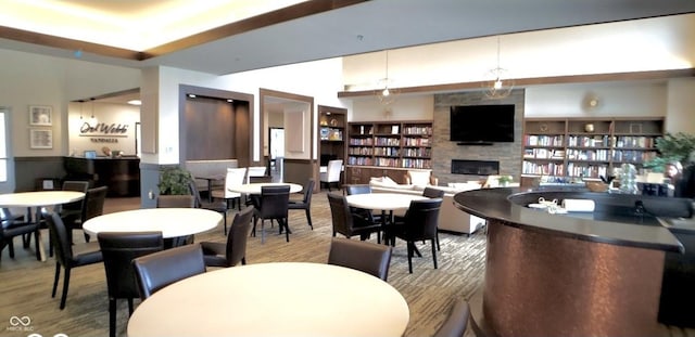 dining room featuring built in features, wood finished floors, and a fireplace