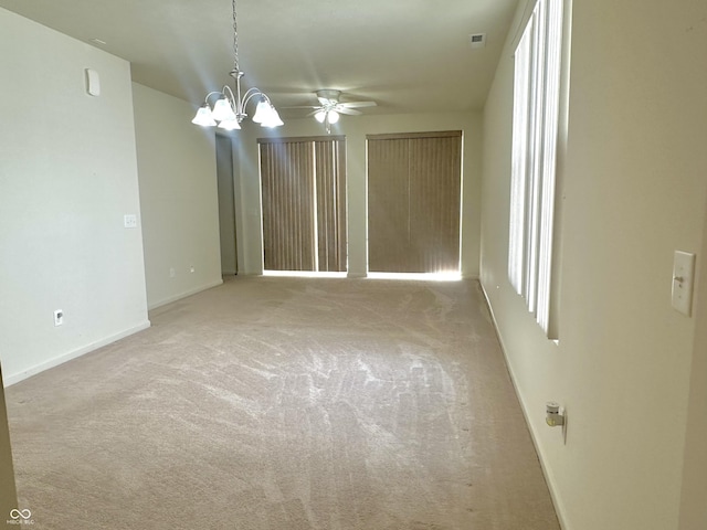 unfurnished room featuring a chandelier, visible vents, baseboards, and carpet