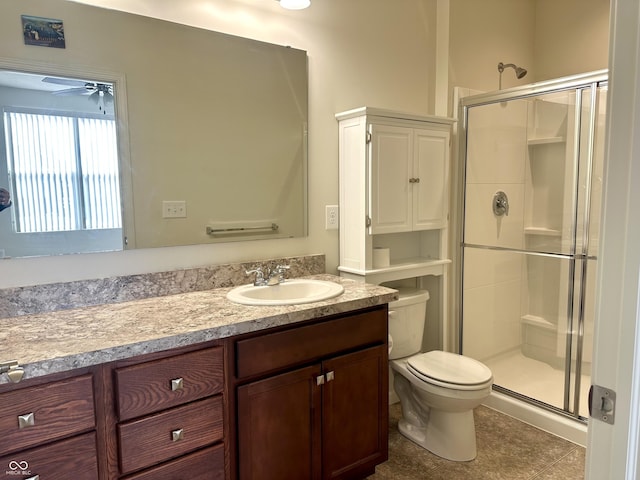 bathroom featuring a shower stall, toilet, vanity, and a ceiling fan