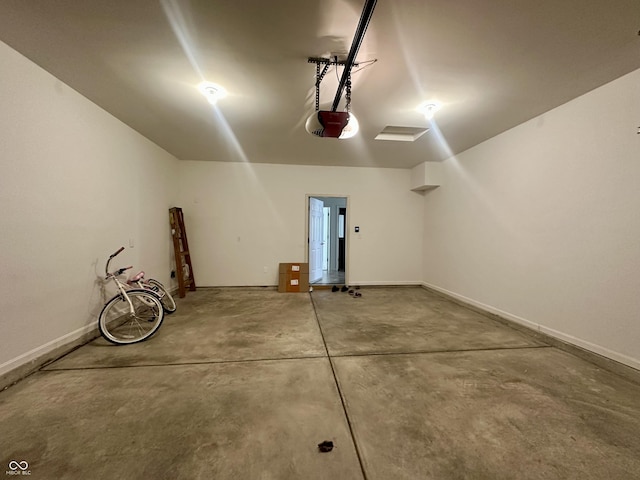 garage with a garage door opener and baseboards