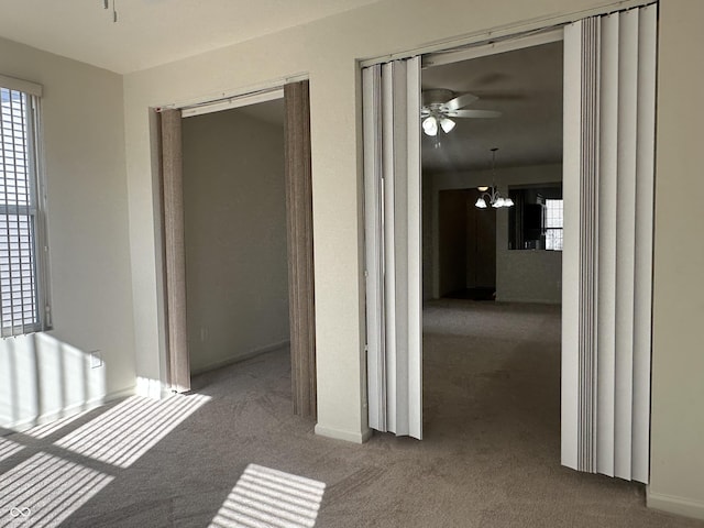 hall featuring an inviting chandelier and carpet flooring