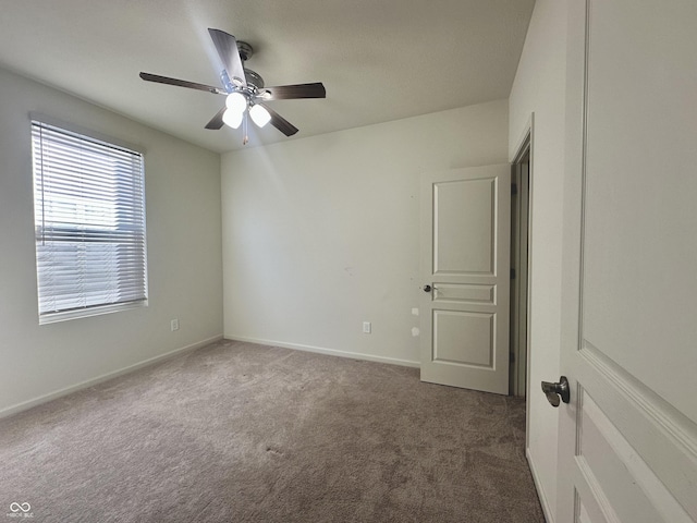 empty room featuring carpet flooring, a ceiling fan, and baseboards