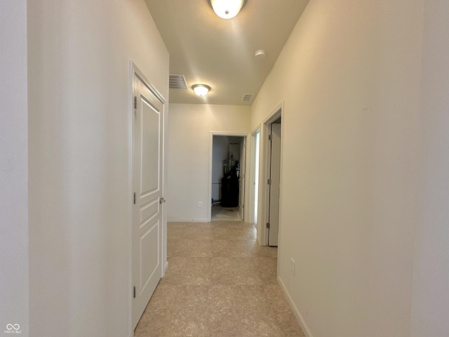 hallway with visible vents and baseboards