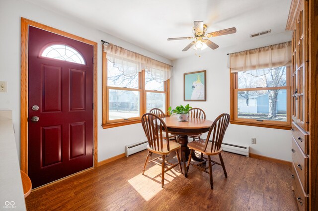 dining area featuring a baseboard radiator, baseboards, and wood finished floors