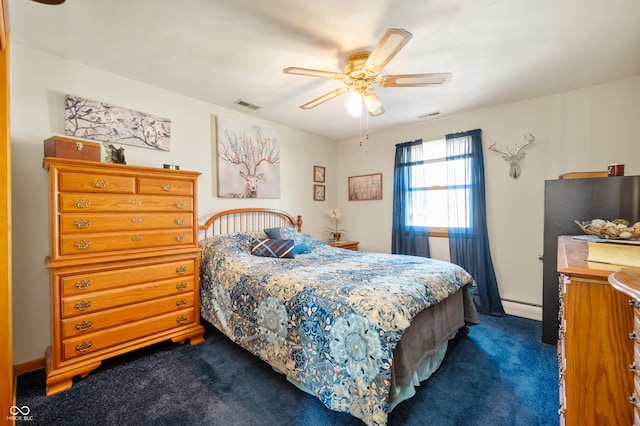 bedroom with visible vents, dark carpet, a ceiling fan, and a baseboard radiator