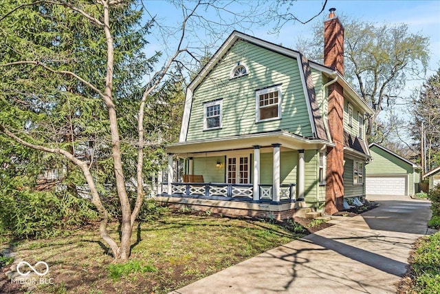 140 E 44th St, Indianapolis, IN 46205 - view of front facade featuring an outdoor structure, a gambrel roof, a chimney, a detached garage, and a porch