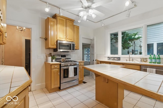 140 E 44th St, Indianapolis, IN 46205 - kitchen featuring track lighting, tile counters, and stainless steel appliances