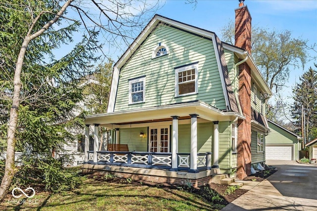 140 E 44th St, Indianapolis, IN 46205 - view of front of home with an outdoor structure, covered porch, a detached garage, and a chimney