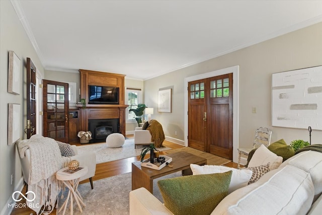 140 E 44th St, Indianapolis, IN 46205 - living room featuring baseboards, ornamental molding, light wood-style floors, and a glass covered fireplace