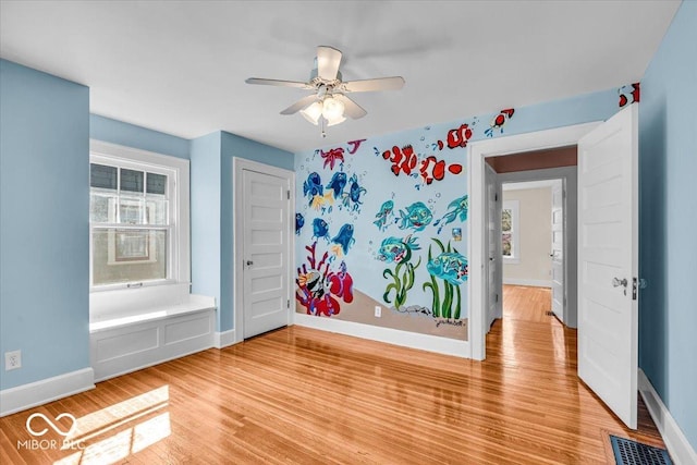 140 E 44th St, Indianapolis, IN 46205 - unfurnished room featuring baseboards, a ceiling fan, light wood-style floors, and plenty of natural light