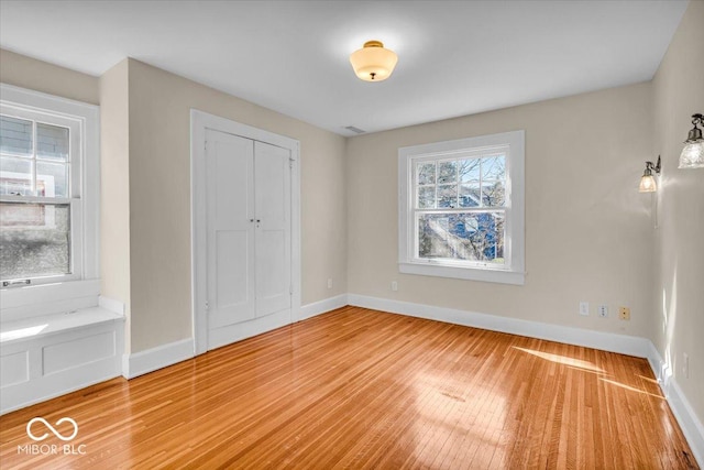 140 E 44th St, Indianapolis, IN 46205 - unfurnished bedroom featuring baseboards, wood finished floors, and a closet