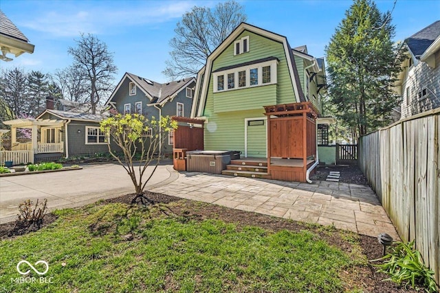 140 E 44th St, Indianapolis, IN 46205 - view of front facade featuring a patio, a gambrel roof, a fenced backyard, and a hot tub