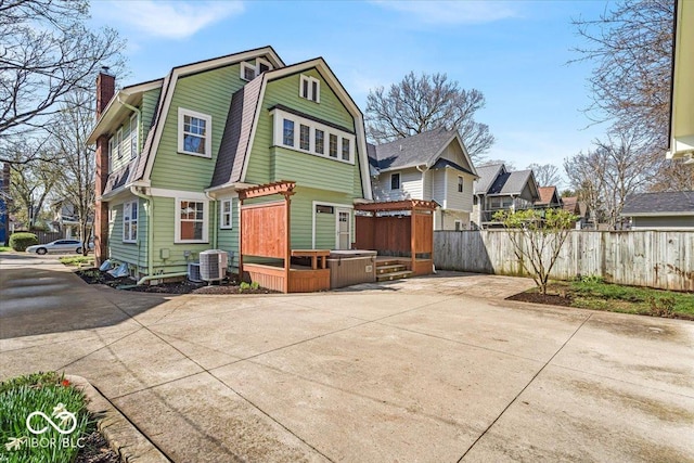 140 E 44th St, Indianapolis, IN 46205 - back of property featuring a chimney, fence, a gambrel roof, a wooden deck, and central AC