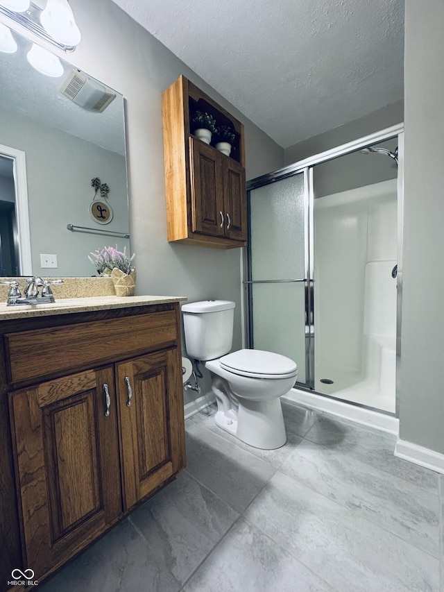 bathroom featuring toilet, a stall shower, and a textured ceiling