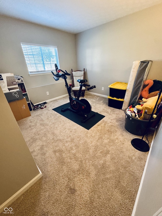 workout room with baseboards and carpet