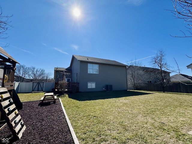 view of side of property featuring central AC unit, a lawn, and a fenced backyard