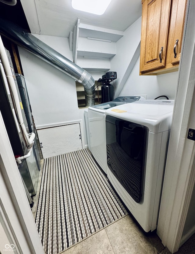 clothes washing area with cabinet space and independent washer and dryer