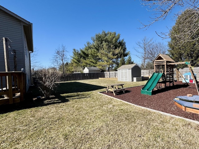 view of play area featuring an outbuilding, a yard, a fenced backyard, and a shed