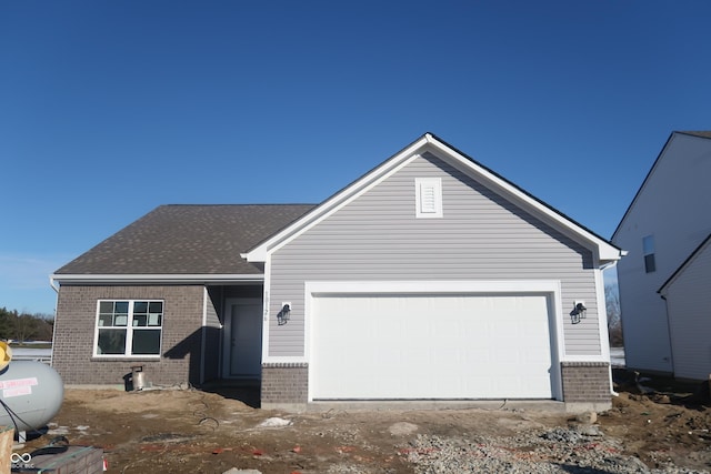 single story home featuring brick siding, a shingled roof, and a garage