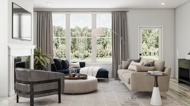 sitting room with recessed lighting, plenty of natural light, wood finished floors, and a fireplace