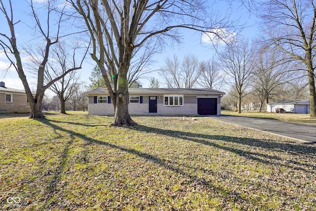 view of front facade with a front lawn, an attached garage, brick siding, and driveway