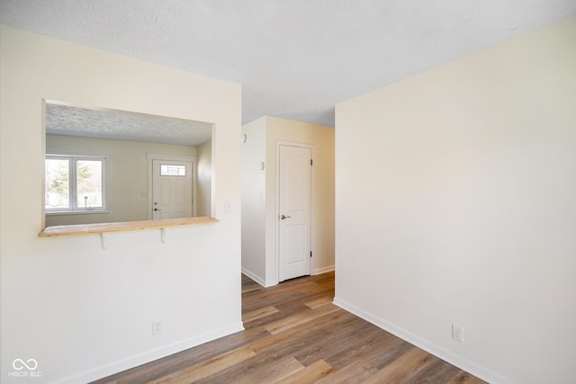 spare room with baseboards and wood finished floors