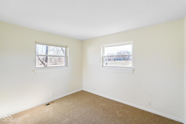 spare room featuring visible vents, baseboards, and carpet