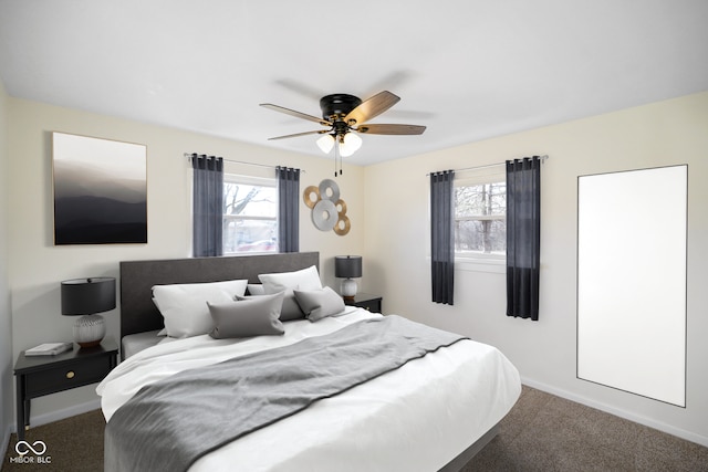 carpeted bedroom with multiple windows, a ceiling fan, and baseboards