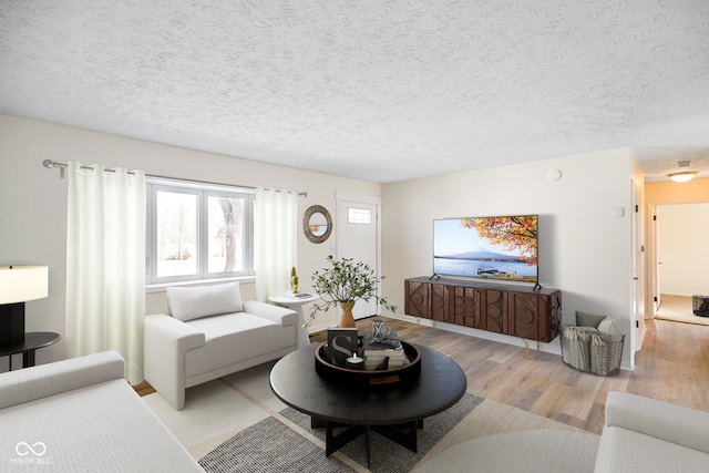 living room featuring a textured ceiling and light wood-style floors