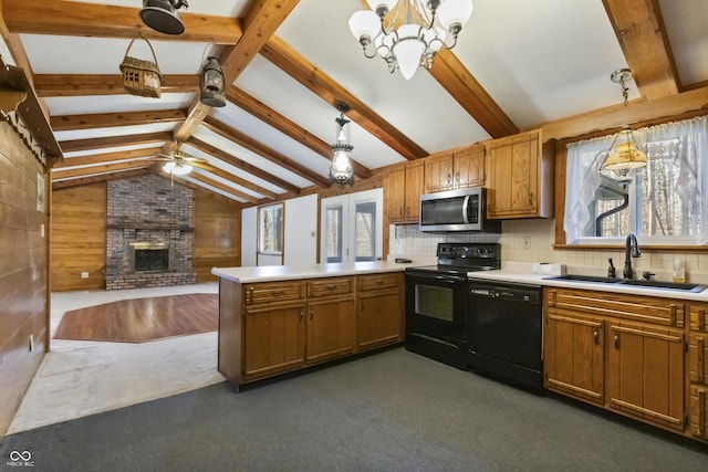 kitchen featuring black appliances, a sink, a peninsula, a brick fireplace, and vaulted ceiling with beams