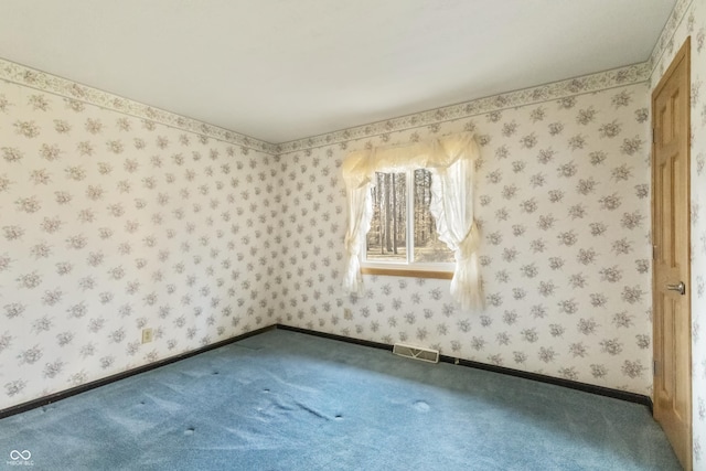 carpeted empty room with visible vents, wallpapered walls, and baseboards