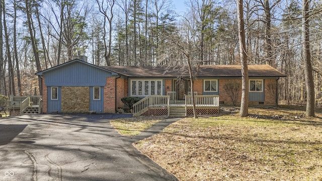 ranch-style home with crawl space, brick siding, and aphalt driveway