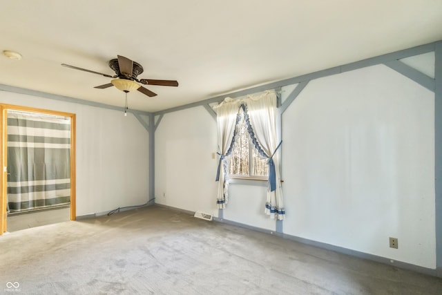 empty room featuring visible vents, baseboards, ceiling fan, and carpet flooring