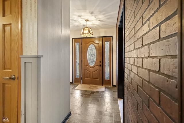 entryway with stone tile flooring and brick wall