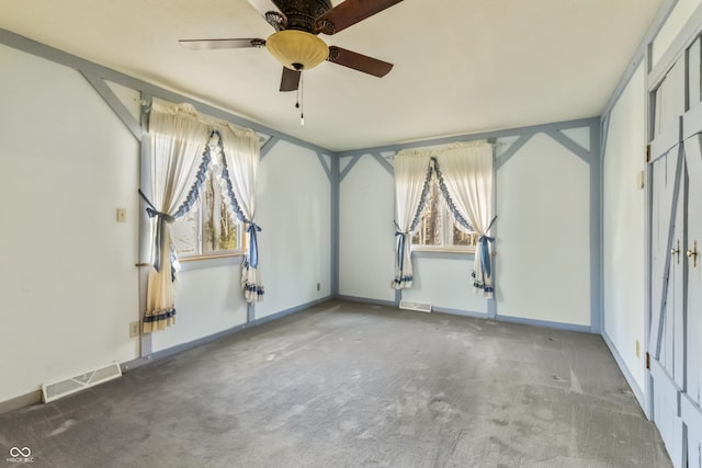 carpeted spare room featuring visible vents, baseboards, and ceiling fan